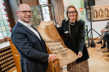 Mayor Michael Gerdhenrich presents Dr Gabriele Uelsberg with the City of Beckum's contribution to the emerging House of History, a jute cement sack from the 1920s.