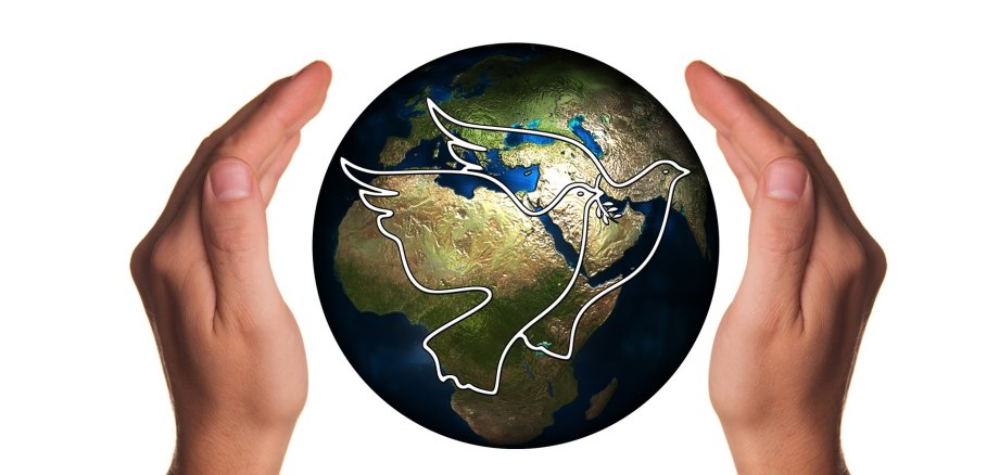 Earth with doves of peace and protective hands