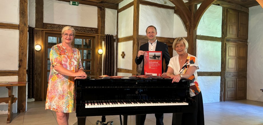 The programme managers stand at the grand piano