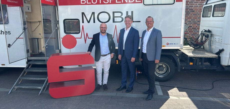 Sparkassen-Vorstand und Bürgermeister am Blutspendemobil