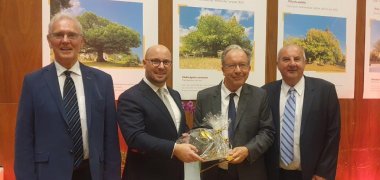 Bürgermeister Michael Gerdhenrich überreicht sein Geschenk an Olivier Delaporte