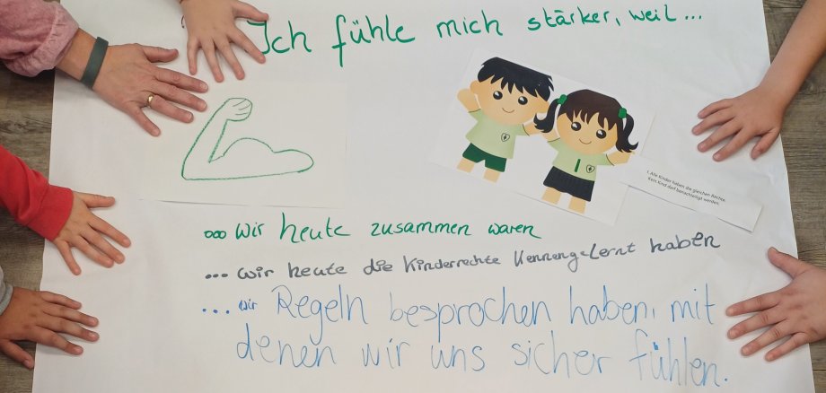 Kinderhände auf einem beschrifteten Plakat